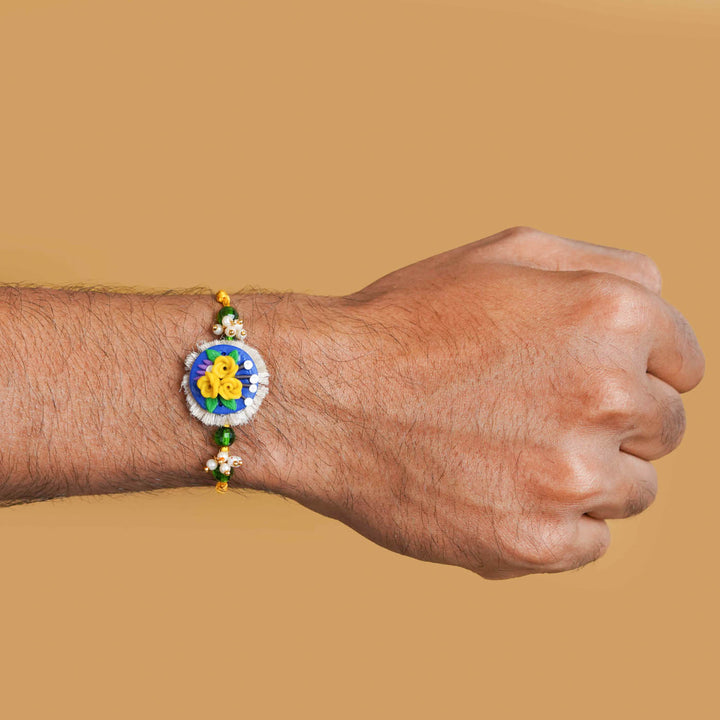 Handmade Miniature Clay Yellow and Blue Floral Rakhi With Roli Chawal