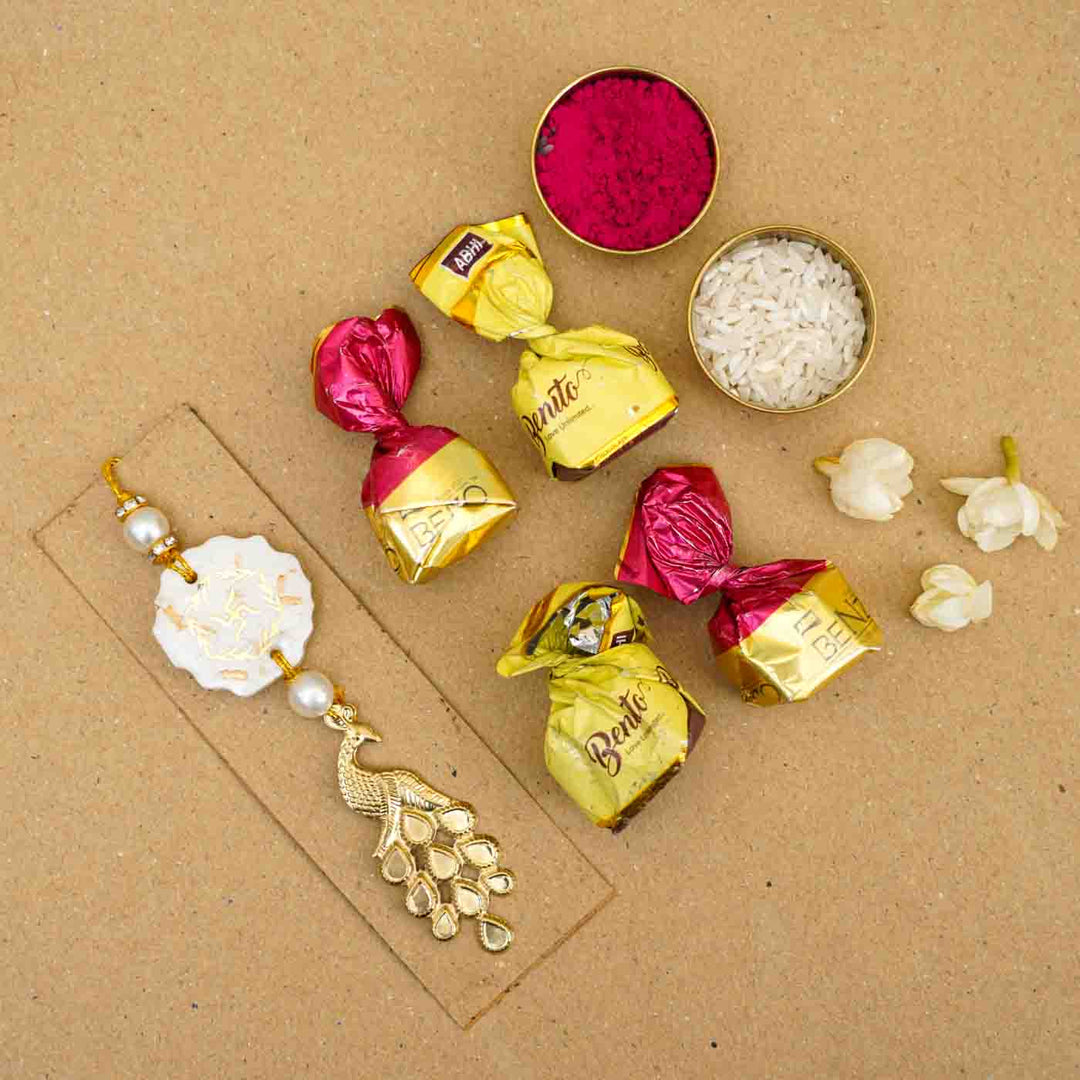 Personalized Handmade White Resin Lumba Rakhi For Bhabhi With Roli Chawal - Flat Lay with Sweets and Flowers