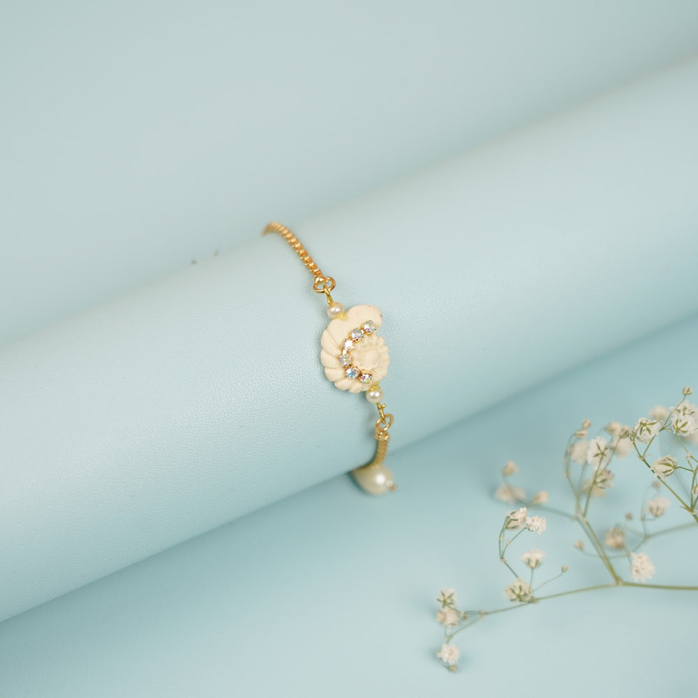 Handmade Golden Shell Clay Bracelet Rakhi With Roli Chawal For Sisters - Wrapped Around Display Cylinder with Props