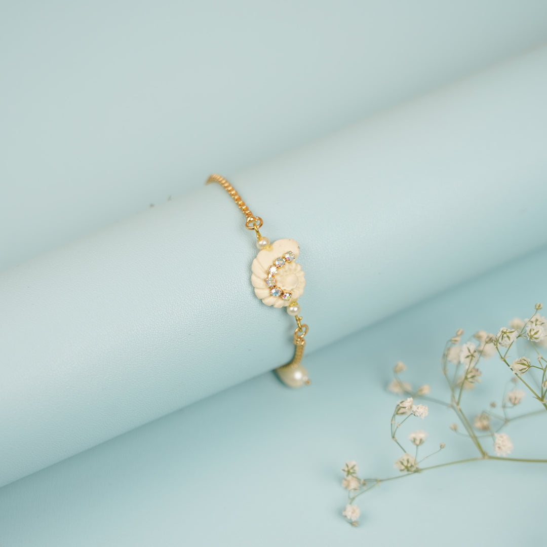 Handmade Golden Shell Clay Bracelet Rakhi With Roli Chawal For Sisters - Wrapped Around Display Cylinder with Props