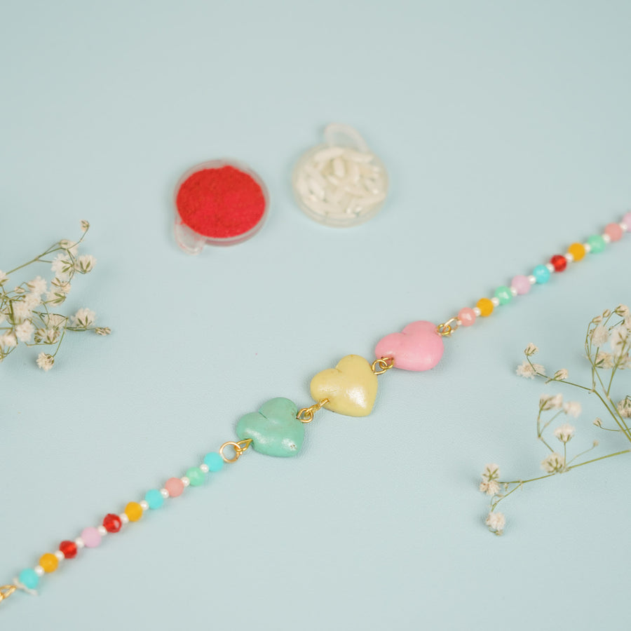 Handmade Beaded Multicolour Hearts Clay Bracelet Rakhi With Roli Chawal For Sisters - Close-up of bracelet beads