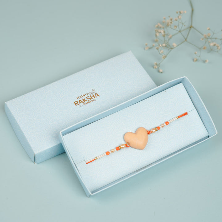 Handmade Beaded Orange Heart Shaped Clay Rakhi With Roli Chawal - Beige heart rakhi in gift box