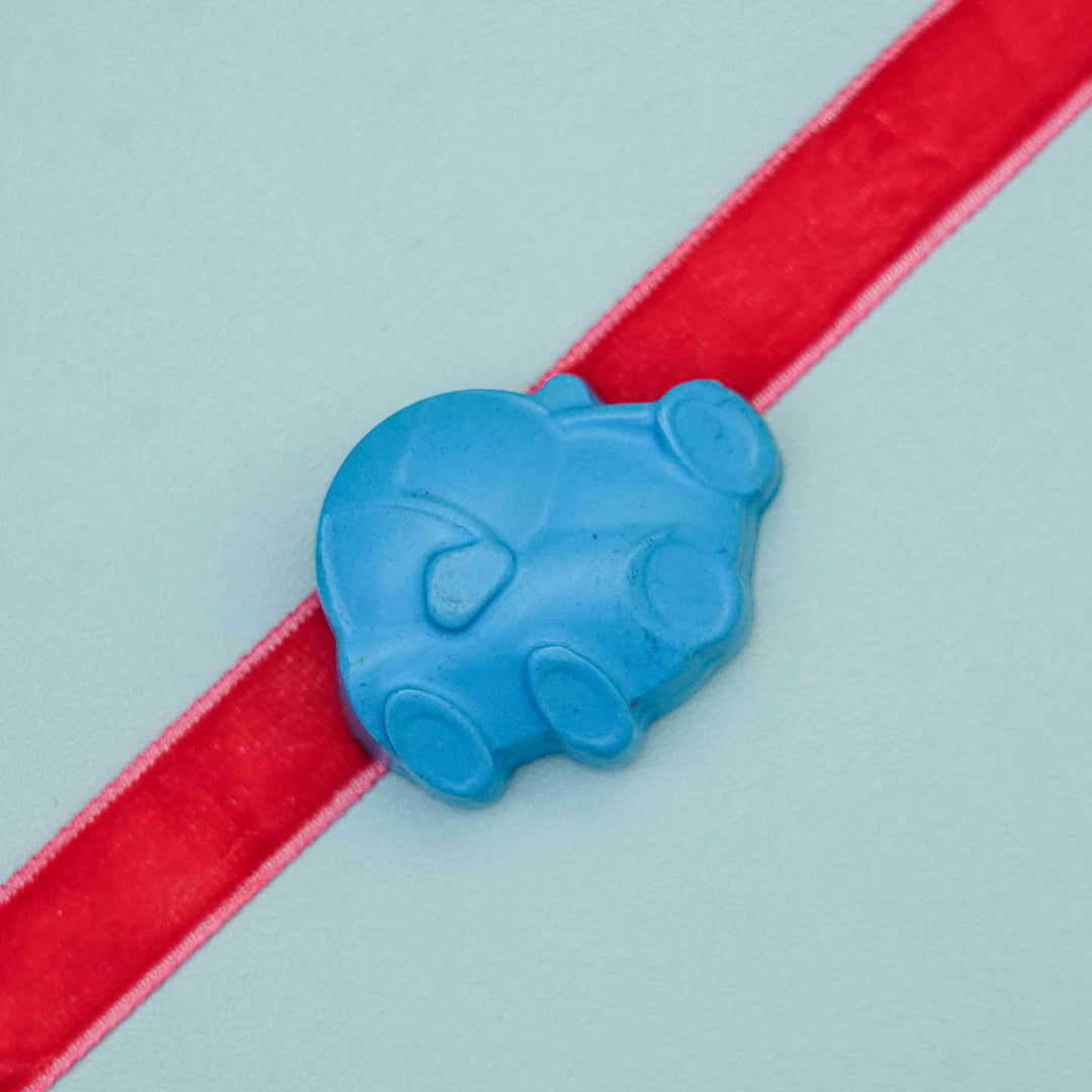 Handmade Car Crayon Kids Rakhi With Roli Chawal - Close-up of blue car on red ribbon