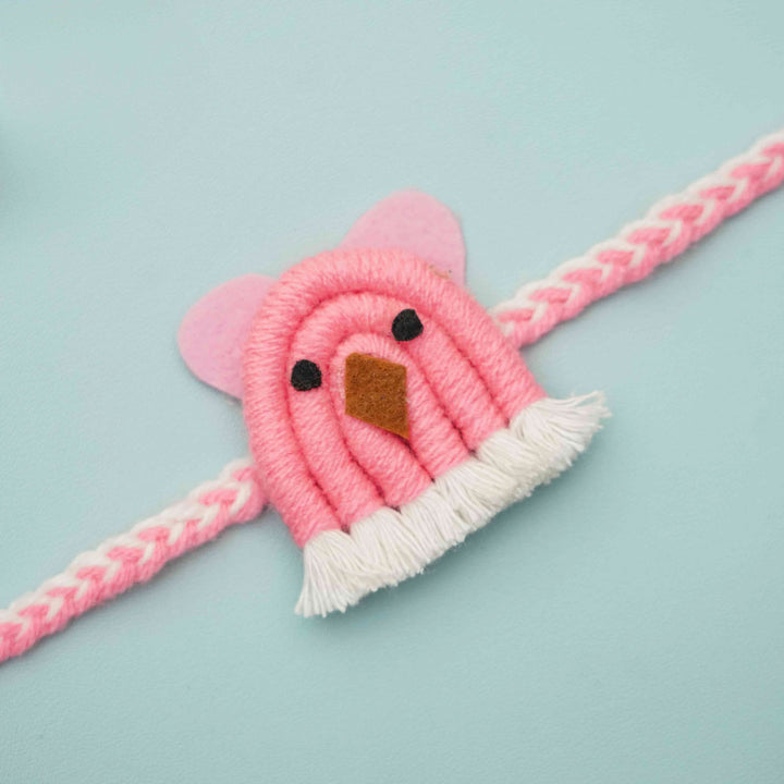 Handmade Macrame Pink Animal Design Cotton Kids Rakhi With Chocolates And Roli Chawal - Close-up of Pink Bird Bracelet