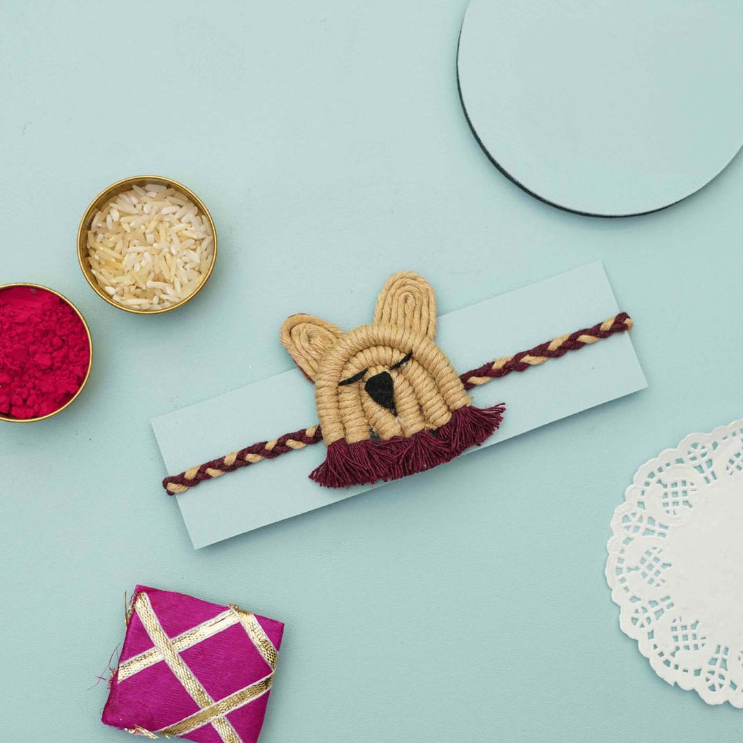 Handmade Macrame Brown Lion Design Cotton Kids Rakhi With Chocolates And Roli Chawal - Braided band displayed on card