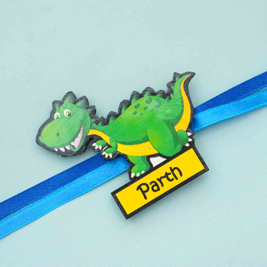 Personalized Reusable X Large Dinosour Mdf Wood Rakhi With Chocolates And Roli Chawal - Close-up of Personalized Dinosaur