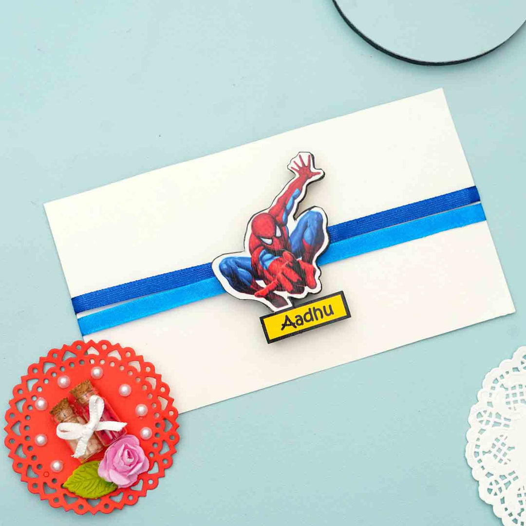 Personalized Reusable X Large Spiderman Name Mdf Wood Rakhi With Chocolates And Roli Chawal - Gift envelope with charm attached