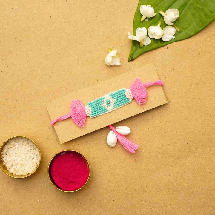Reusable Beaded Evil Eye Lumba Rakhi For Bhabhi With Roli Chawal - Flat lay with festive elements