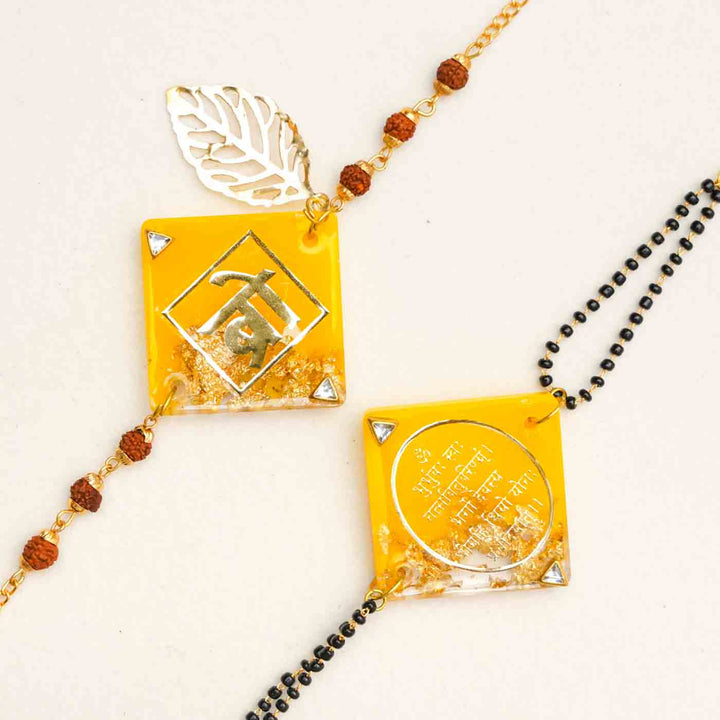 Handmade Resin Sunset Yellow Bhaiya Bhabhi Rakhi With Chocolates And Roli Chawal Set Of 2 - Close-up of two Rakhi charms