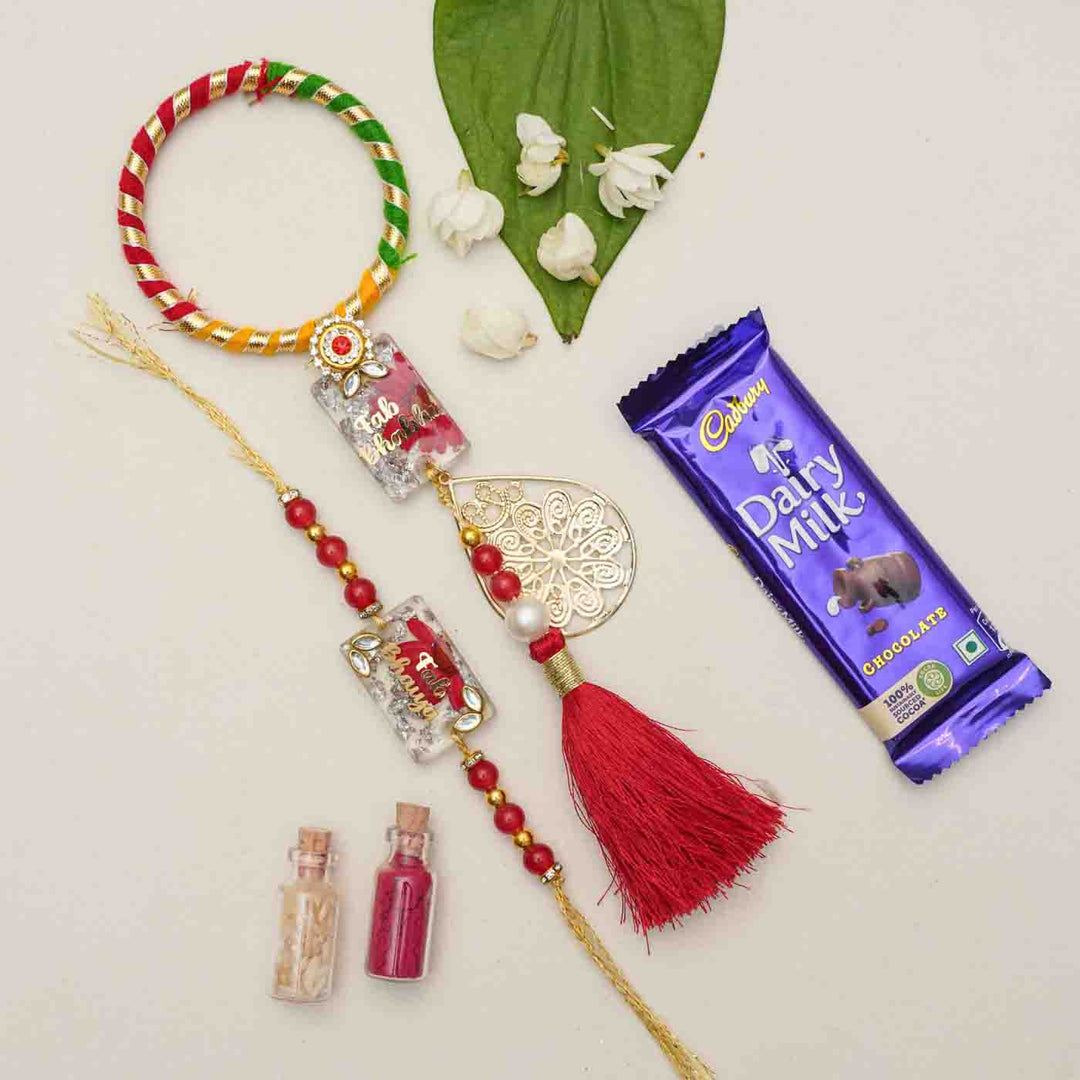 Handmade Resin Fab Bhaiya And Fab Bhabhi Rakhi With Chocolates And Roli Chawal Set Of 2 - Styled with gift and flowers