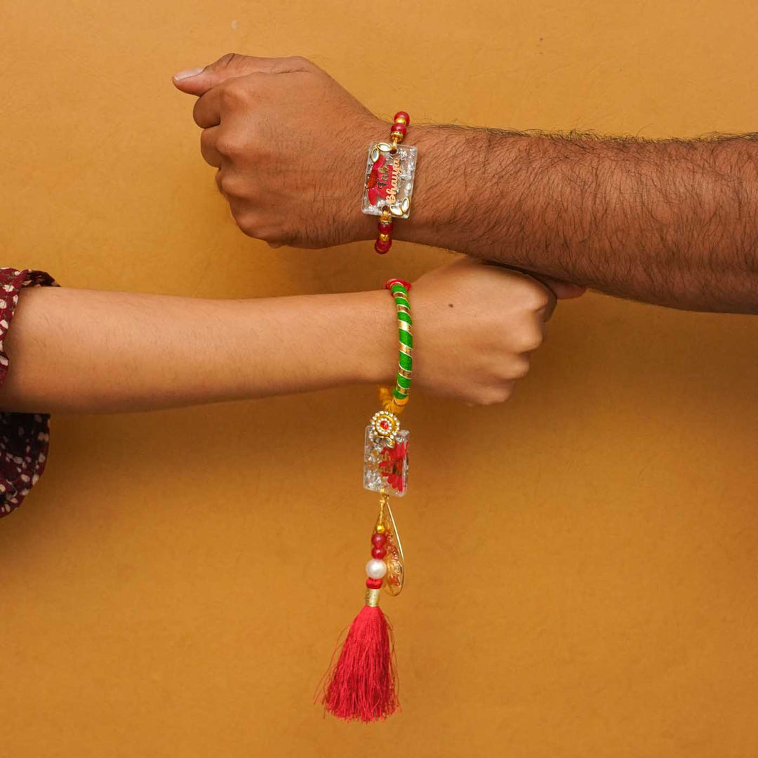 Handmade Resin Fab Bhaiya And Fab Bhabhi Rakhi With Chocolates And Roli Chawal Set Of 2 - Rakhi worn on wrists