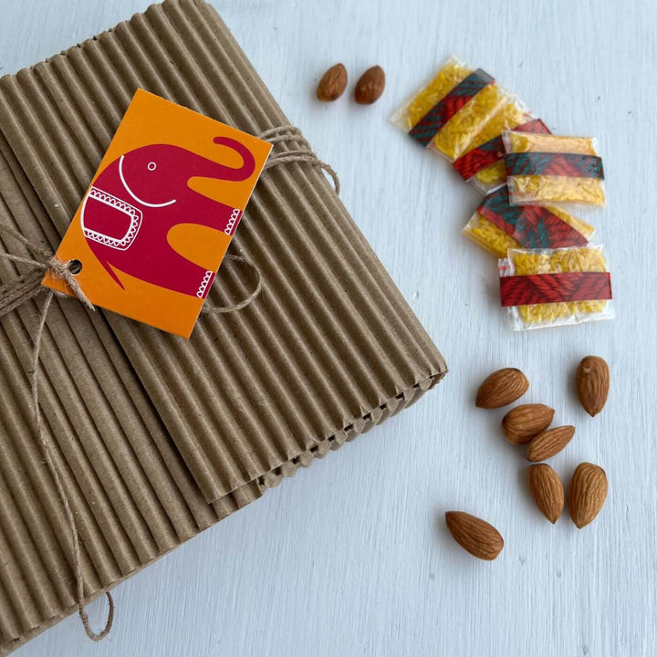 Handcrafted Folk Art Rakhi Hamper For Kids With Rice Roli Haldi 3 - Gift wrapping with almonds and roli packets