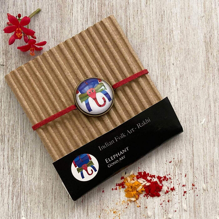 Handcrafted Folk Art Rakhi Hamper For Kids With Rice Roli Haldi 2 - Rakhi on gift packaging close-up