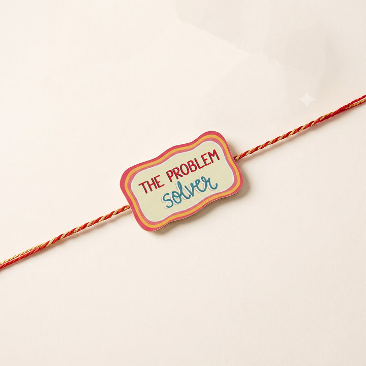 Glossy Printed Wooden 'Problem Solver' Rakhi With Kumkum Rice For Brother