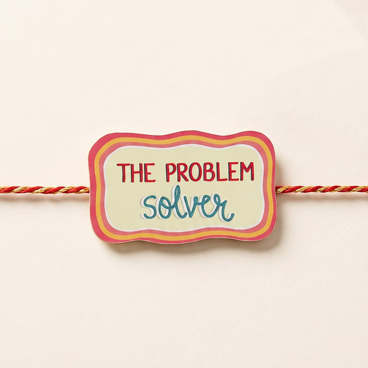 Glossy Printed Wooden 'Problem Solver' Rakhi With Kumkum Rice For Brother