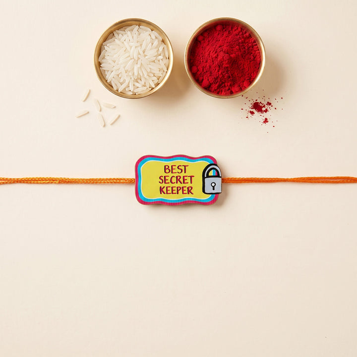 Glossy Printed Wooden 'Best Secret Keeper' Rakhi With Kumkum Rice For Brother