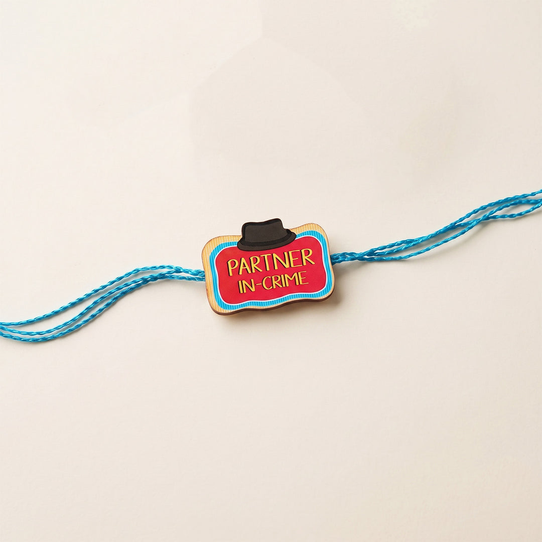 Glossy Printed Wooden 'Partner In Crime' Rakhi With Kumkum Rice For Brother