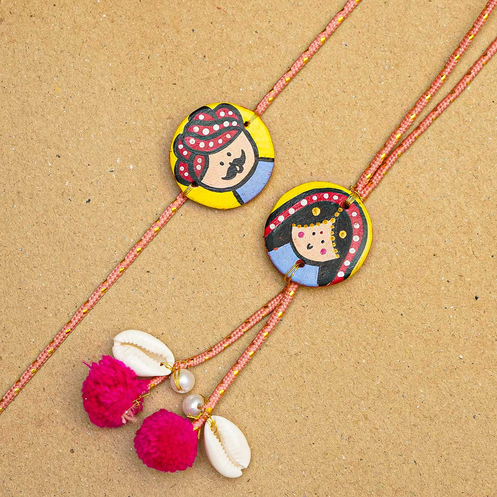 Handcrafted Raja Rani Terracotta Rakhi With Roli Chawal - Close-up of two bracelets