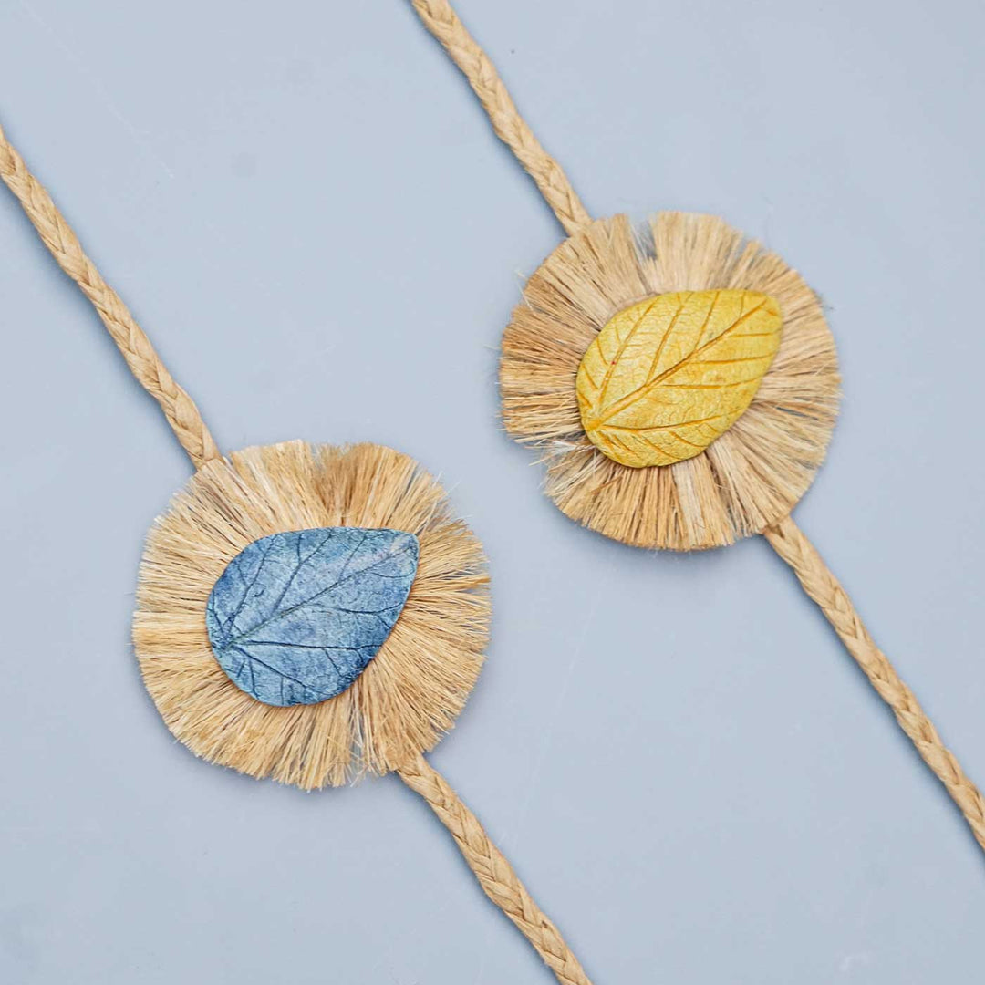 Handmade Papier Mache Yellow And Blue Leaf Rakhi With Roli Chawal Set Of 2 - Close-up of Two Bracelets