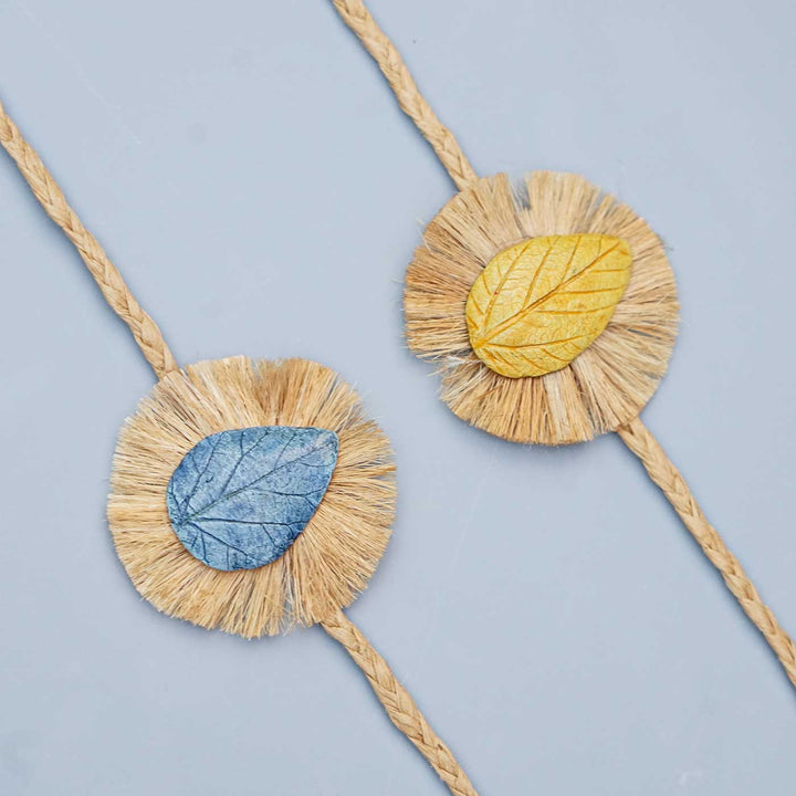 Handmade Papier Mache Yellow And Blue Leaf Rakhi With Roli Chawal Set Of 2 - Close-up of Two Bracelets