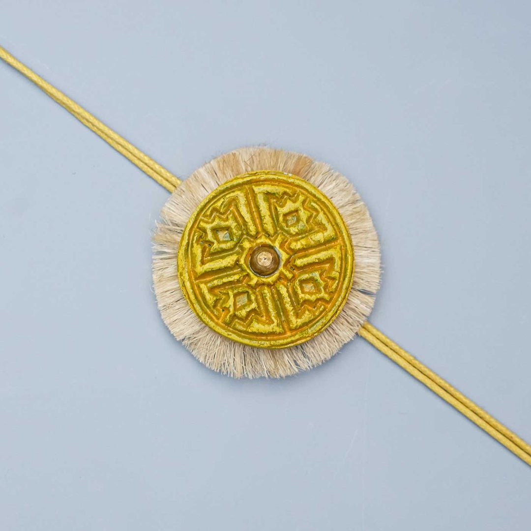 Handmade Papier Mache Swastika With Yellow Thread Rakhi With Roli Chawal - Close-up of Decorative Rakhi
