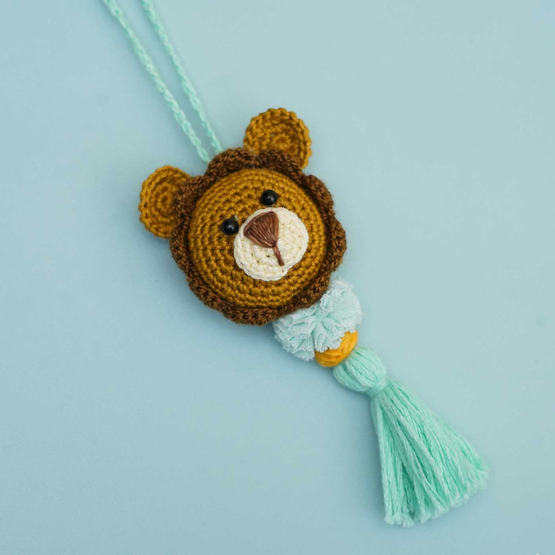 Handmade Crochet Lion Cub Kids Rakhi With Roli Chawal - Product Display on Marble Pods