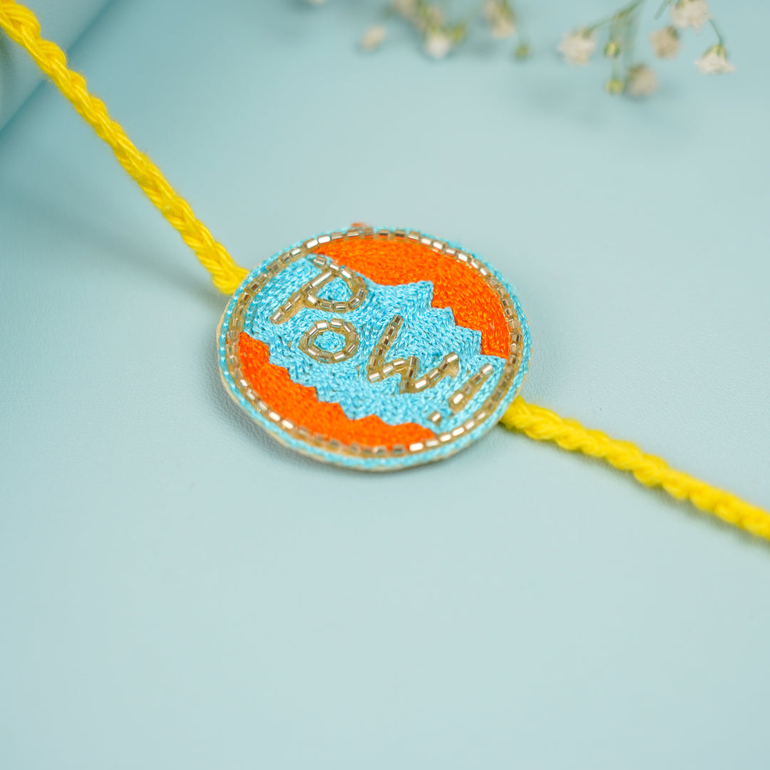 Handmade Beaded Pow Superhero Rakhi With Roli Chawal For Brother - Close-up of Rakhi detail