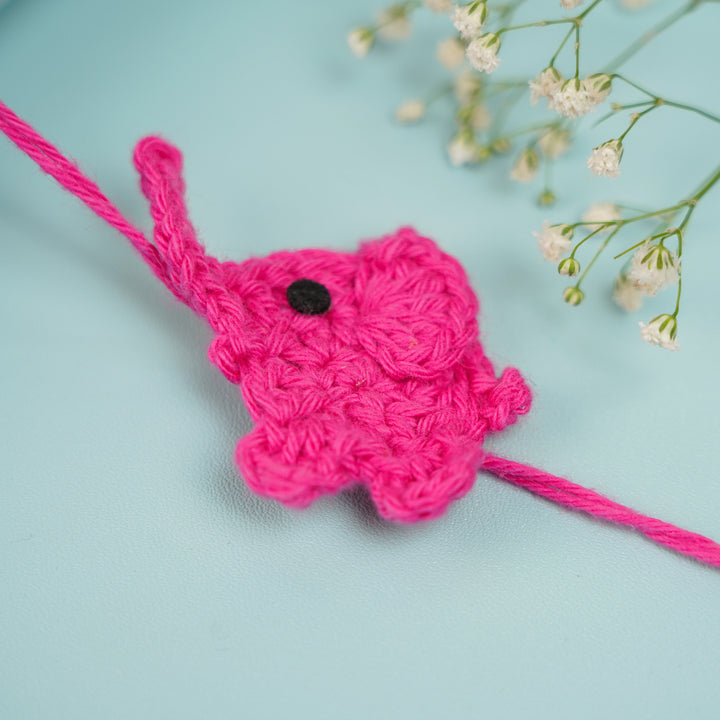 Customized Handmade Crochet Elephant Theme Rakhi With Roli Chawal - Pink Rakhi Close-up with Flowers