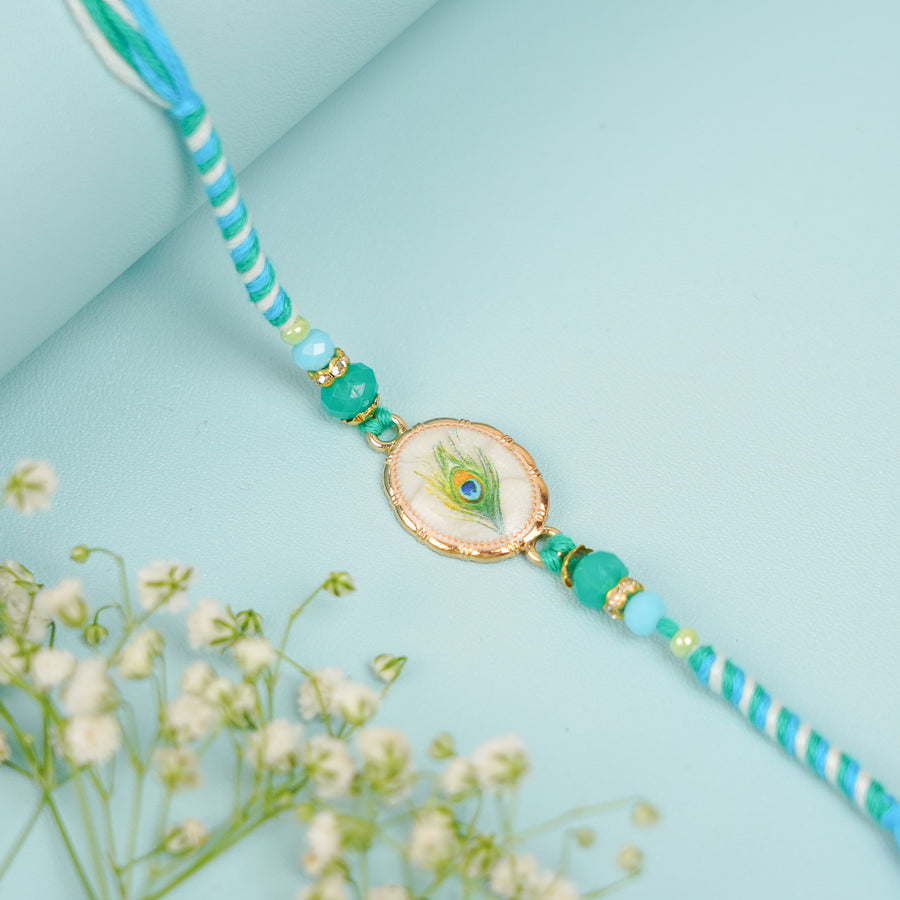 Handmade Beaded Peacock Feather Theme Rakhi With Roli Chawal - Close-up of Rakhi Design
