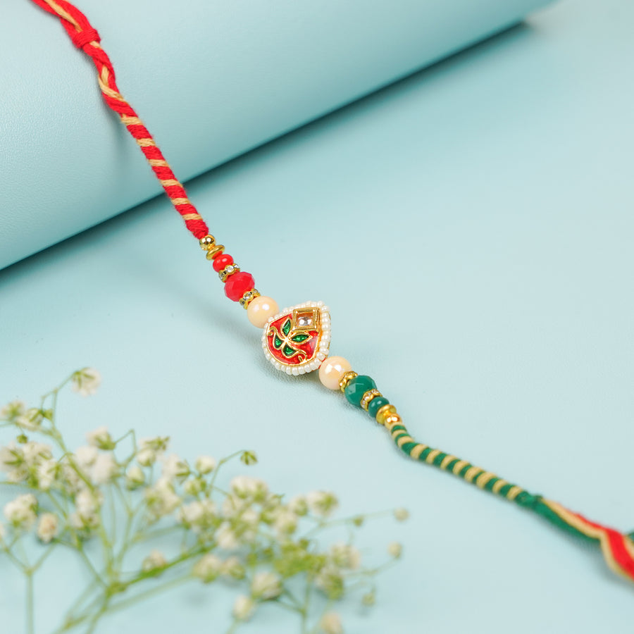 Handmade Green And Red Kundan Rakhi With Roli Chawal - Close-up of decorative center