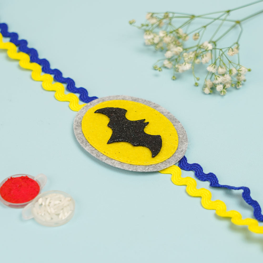 Handmade Batman Theme Felt Kids Rakhi With Roli Chawal 2 - Flat Lay Front View with Props