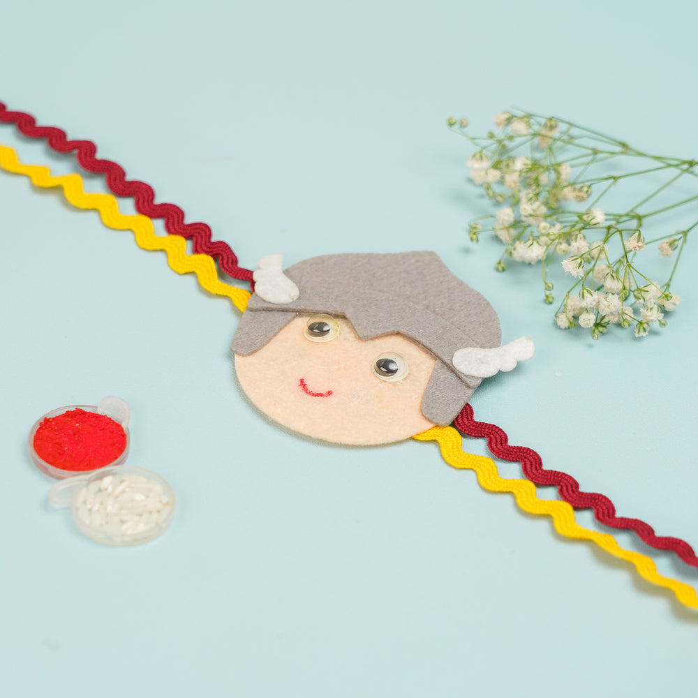 Handmade Thor Theme Felt Kids Rakhi With Roli Chawal - Flat Lay with Accessories and Flowers