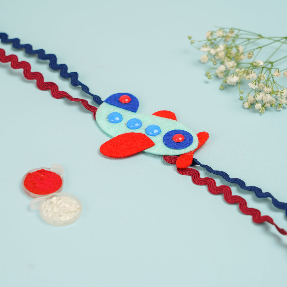 Photo Personalized Aeroplane Theme Felt Rakhi Hamper With Roli Chawal Includes 1 Magnetic Photo Frame 1 Rakhi - Close-up of Airplane Accessory Detail