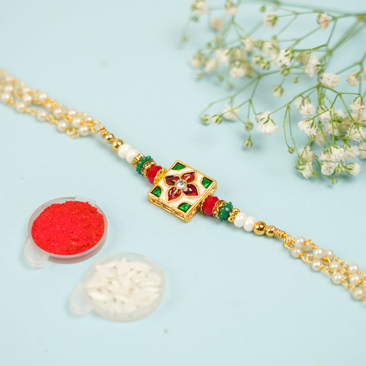 Handmade Square Jadtar And Pearl Bhaiya Bhabhi Rakhi With Roli Chawal Set Of 2 - Flat lay with traditional items