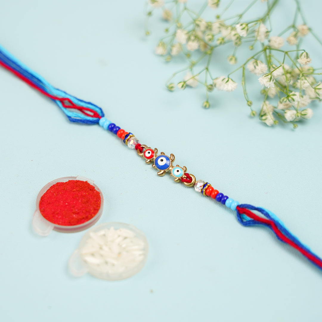 Handmade Beaded Turtle Evil Eye Rakhi With Roli Chawal - Top View with Festival Decoration