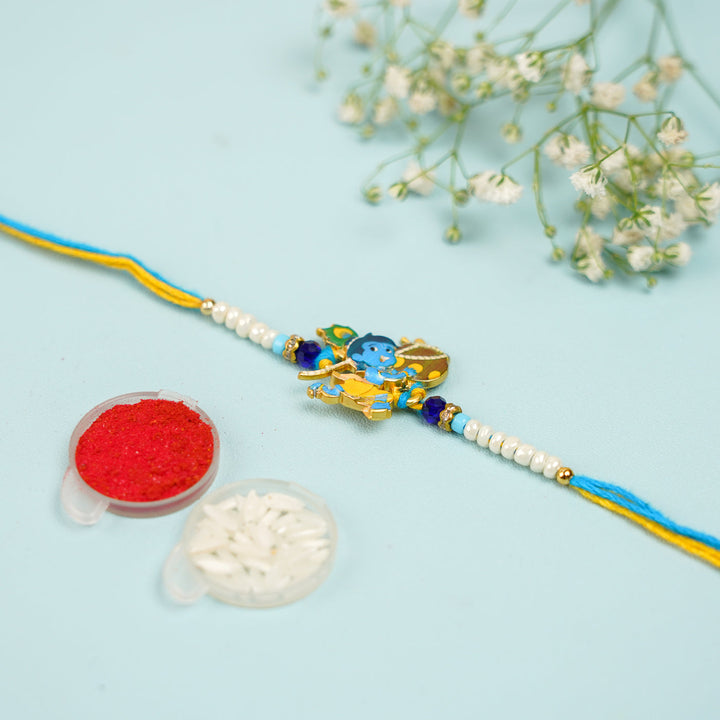 Handmade Baal Krishna Rakhi With Roli Chawal - Flat lay with accessories included