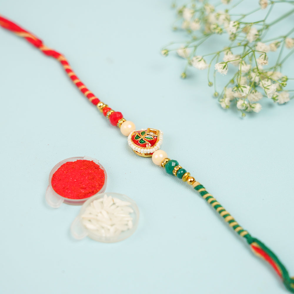 Handmade Green And Red Kundan Rakhi With Roli Chawal - Product with traditional accessory items