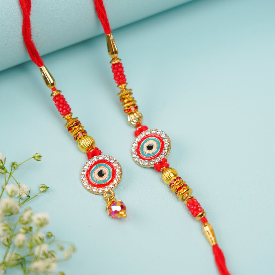 Handmade Red Evil Eye Jadtar Bhaiya Bhabhi Rakhi With Roli Chawal Set Of 2 - Pair Front View with Decorative Items