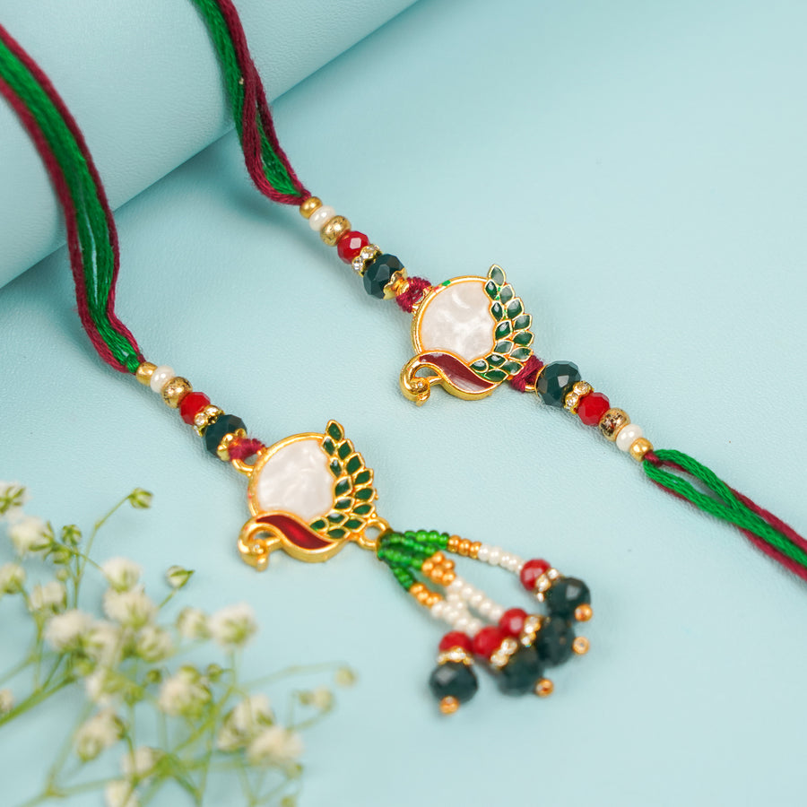 Handmade Beaded Peacock Bhaiya Bhabhi Rakhi With Roli Chawal Set Of 2 - Pair Display on Blue Background
