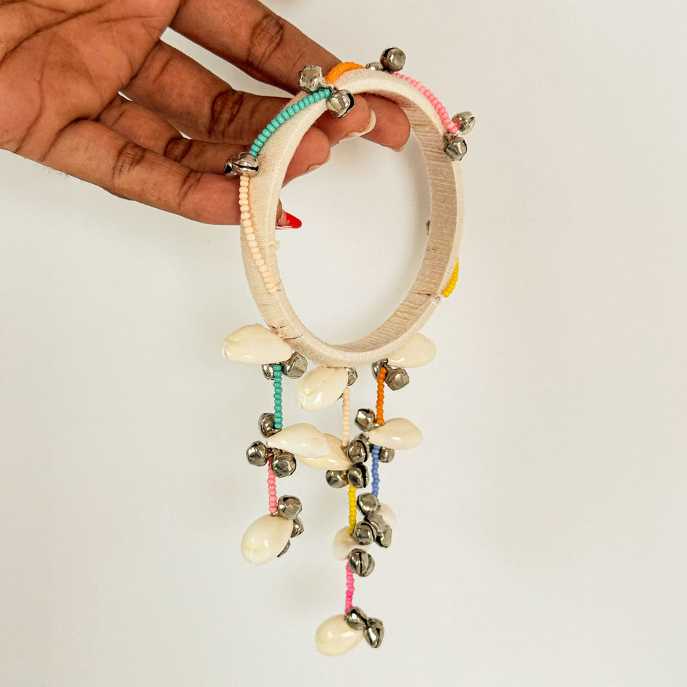 Handmade Beaded White Ghungroo And Shell Cotton Bangle Lumba With Roli Chawal For Bhabhi - Held by Hand Side View