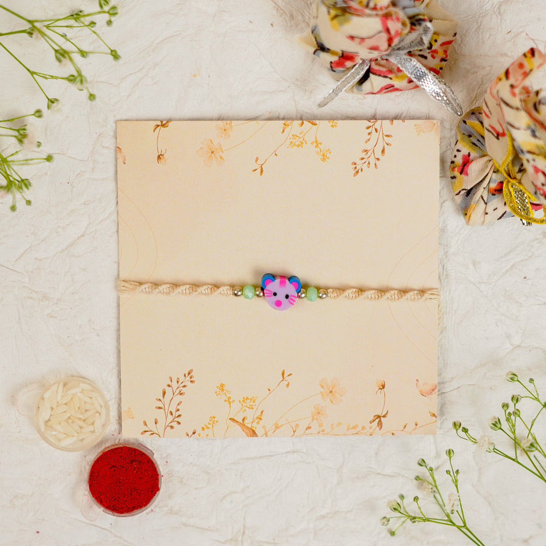 Handmade Cat Kids Rakhi With Roli Chawal 1 - Top-down view on floral card