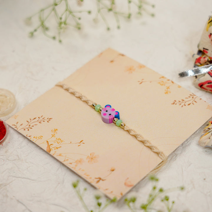 Handmade Cat Kids Rakhi With Roli Chawal 1 - Angled view on floral card