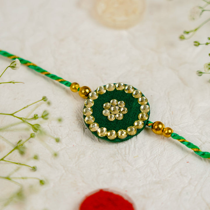 Handmade Silk Crystal Rakhi With Roli Chawal - Close-up of Green Rakhi Center