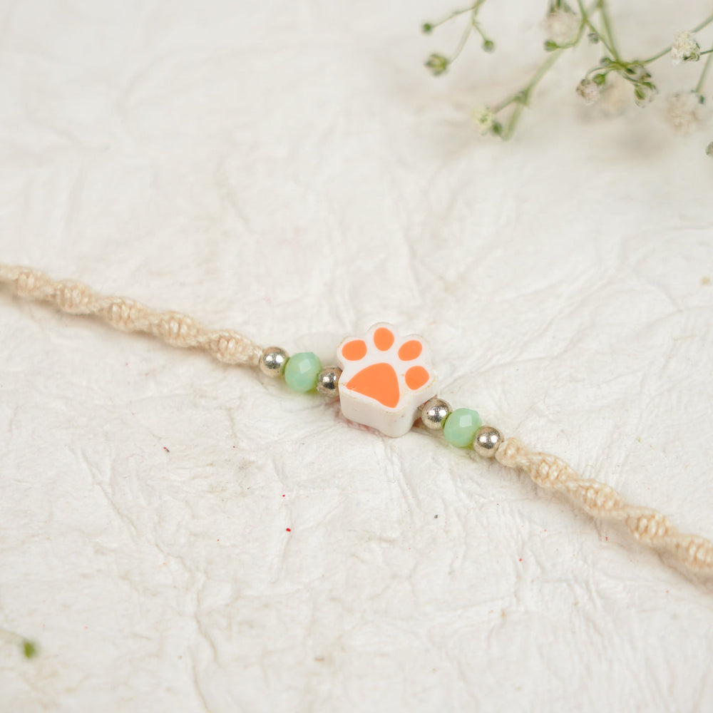 Handmade Paw Kids Rakhi With Roli Chawal - Close-up Orange Paw Charm