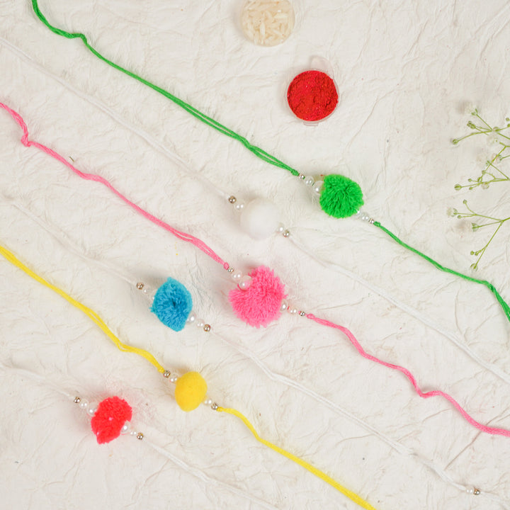 Handmade Large Pompom Rakhi With Roli Chawal Set Of 12 - Bracelets Laid Out Flat
