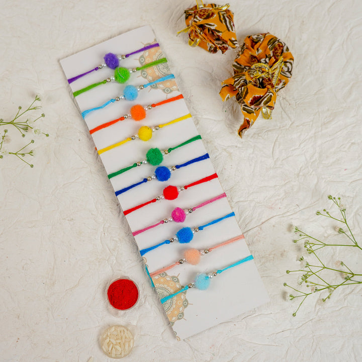 Handmade Small Pompom Rakhi With Roli Chawal Set Of 12 - Top View of Multiple Bracelets