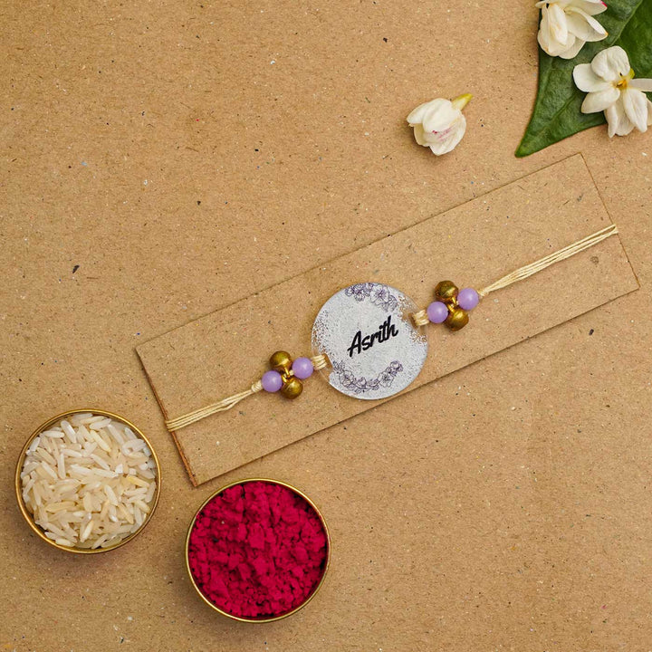 Personalized Hand Painted Name Acrylic Rakhi With Roli Chawal - Flat Lay with Rice and Kumkum
