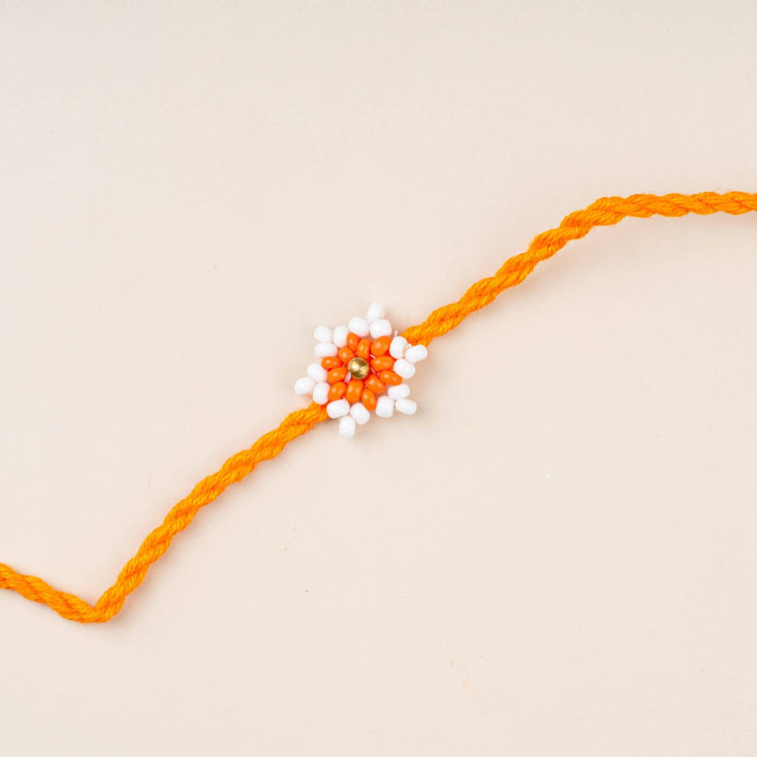 Handcrafted Glass Beads Tara Rakhi 6 - Close-up of orange-white rakhi