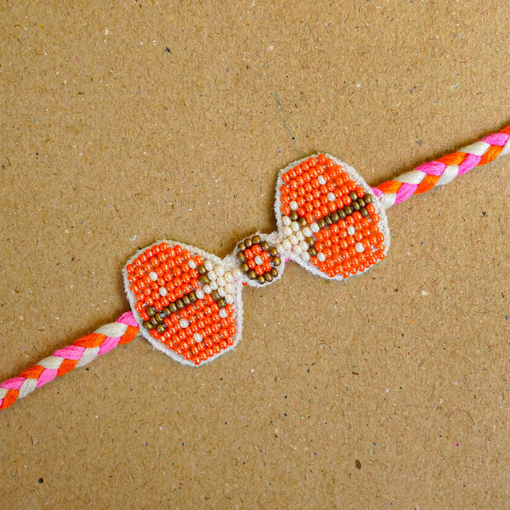 Reusable Beaded Orange Bug Rakhi With Roli Chawal - Close-up of beaded rakhi detail