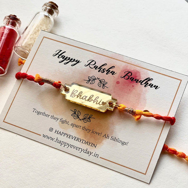 Handcrafted Golden Acrylic Rakhi With Roli Chawal 5 - On packaging card front view